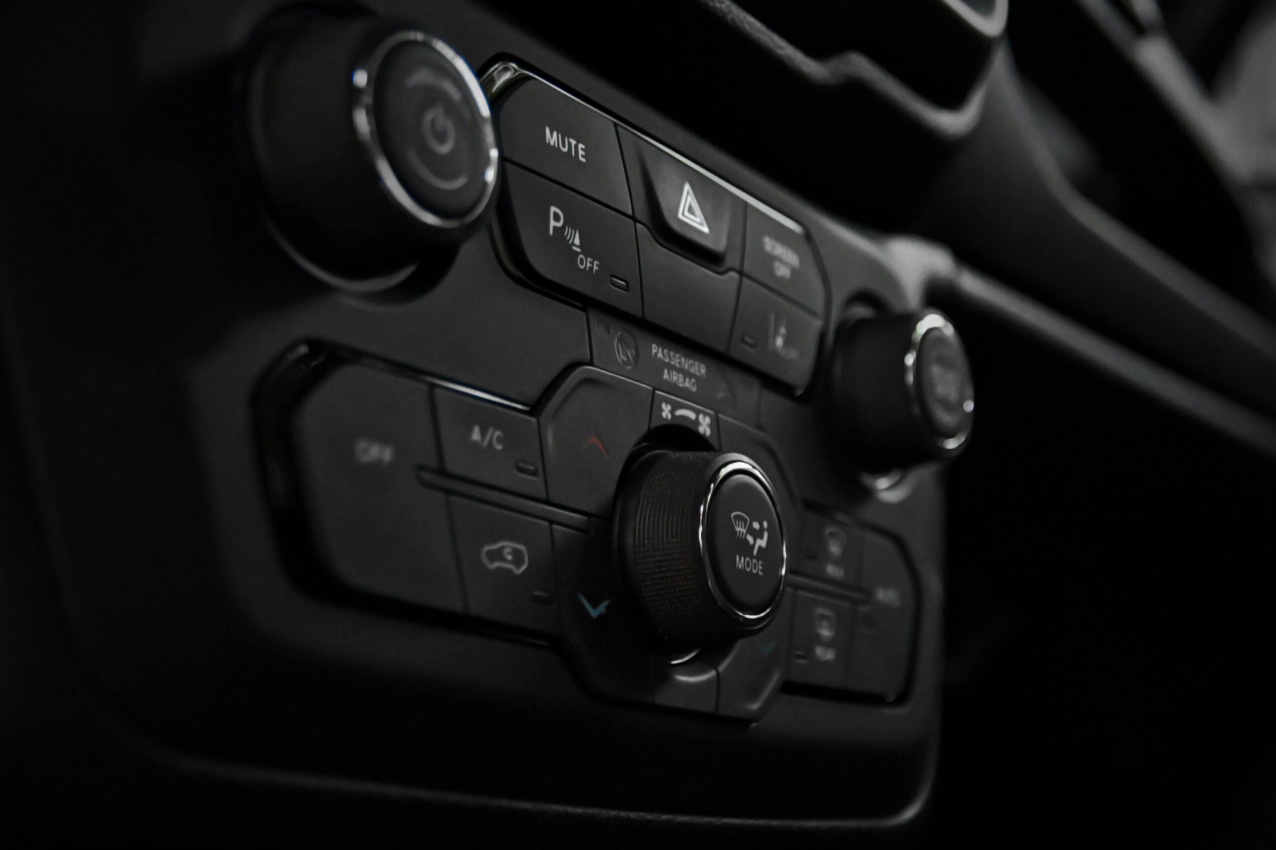 Detailed close-up of a car's control panel featuring various buttons and switches for functionality.