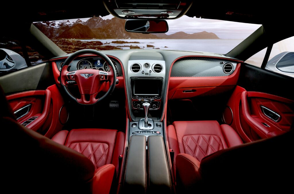 pexels-photo-326259-326259 Red leather luxury sports car interior with mountain backdrop outside the window.