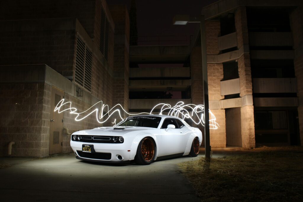 pexels-photo-733745-733745 White luxury sports car parked with dynamic light trails at night against a building backdrop.